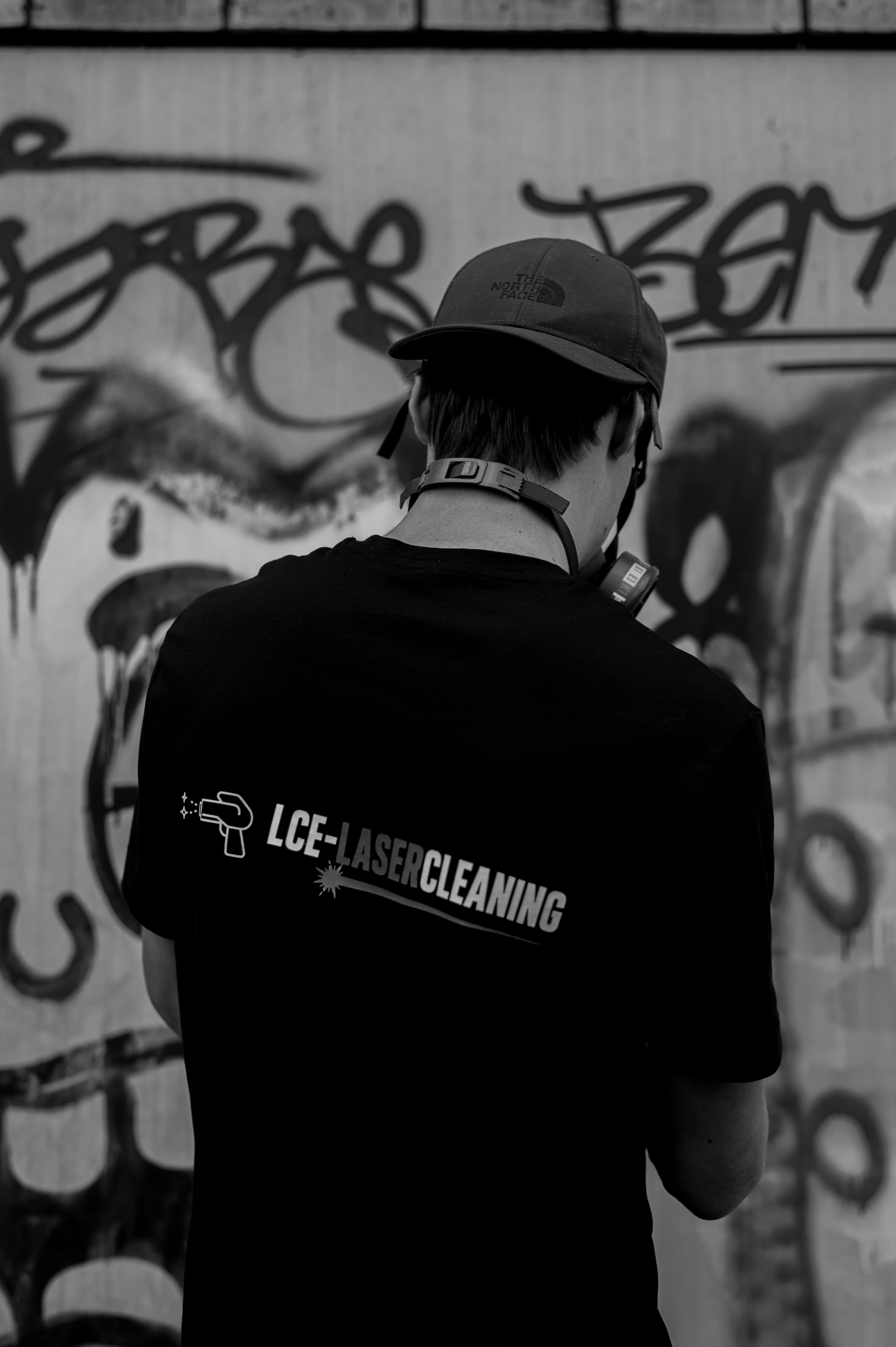 LCE Laser Cleaning — rugaanzicht met logo, graffiti wazig op de achtergrond